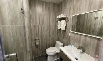 Private guest bathroom with shower and free toiletries at King Hotel Brooklyn.