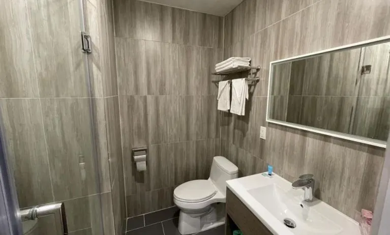 Private guest bathroom with shower and free toiletries at King Hotel Brooklyn.