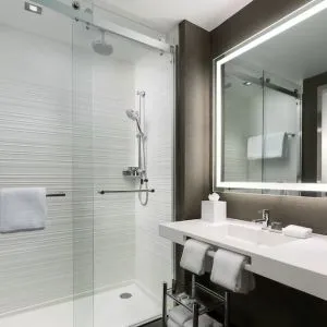 Private guest bathroom with shower and free toiletries at AC Hotel New York Times Square.
