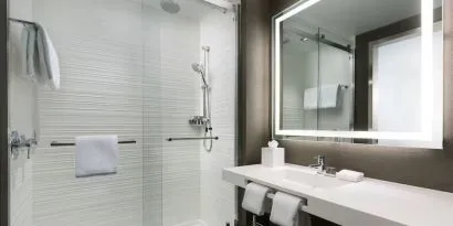 Private guest bathroom with shower and free toiletries at AC Hotel New York Times Square.