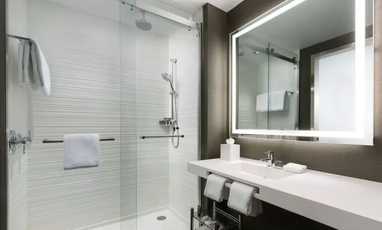 Private guest bathroom with shower and free toiletries at AC Hotel New York Times Square.