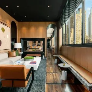 Lounge seating and workspace with fireplace at AC Hotel New York Times Square.