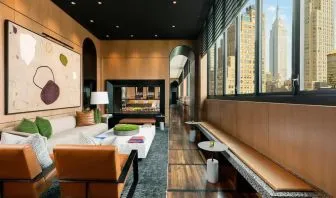 Lounge seating and workspace with fireplace at AC Hotel New York Times Square.
