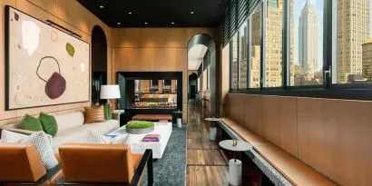 Lounge seating and workspace with fireplace at AC Hotel New York Times Square.