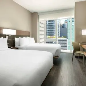 Day use twin room with workspace, floor to ceiling window and private bathroom at AC Hotel New York Times Square.