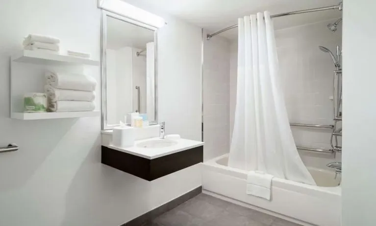 Private guest bathroom with combine shower and tub at Hampton Inn Manhattan Chelsea.