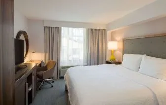 Day use room with king bed, work desk, natural light and private bathroom at Hampton Inn Manhattan Chelsea.