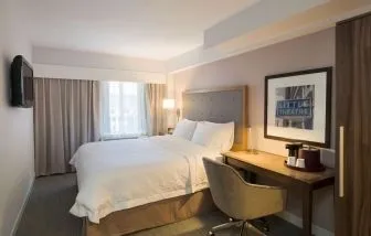 Day use room with king bed, work desk, natural light and private bathroom at Hampton Inn Manhattan - Madison Square Garden.