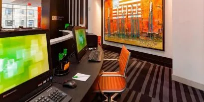 Business center with computers, printer and ergonomic chairs at Courtyard By Marriott New York Manhattan/Central Park.