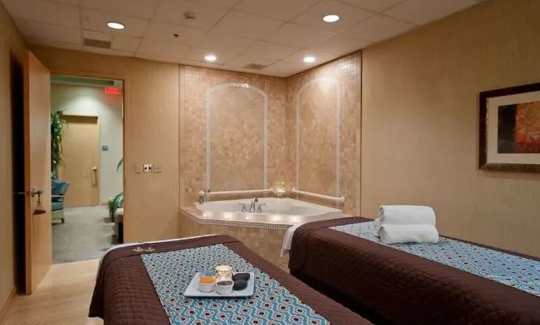 Spa with jacuzzi and massage tables at Embassy Suites By Hilton Charlotte-Concord-Golf Resort & Spa.