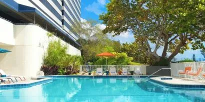 Outdoor pool with lounge chairs at Sheraton Miami Airport Hotel.