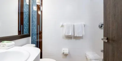 Private guest bathroom with combined shower and tub at Regency Miami Airport By Sonesta.