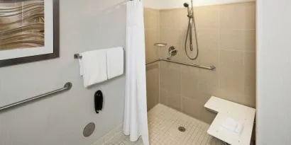 Private guest bathroom with accesible shower and free toiletries at Courtyard Miami Dolphin Mall.