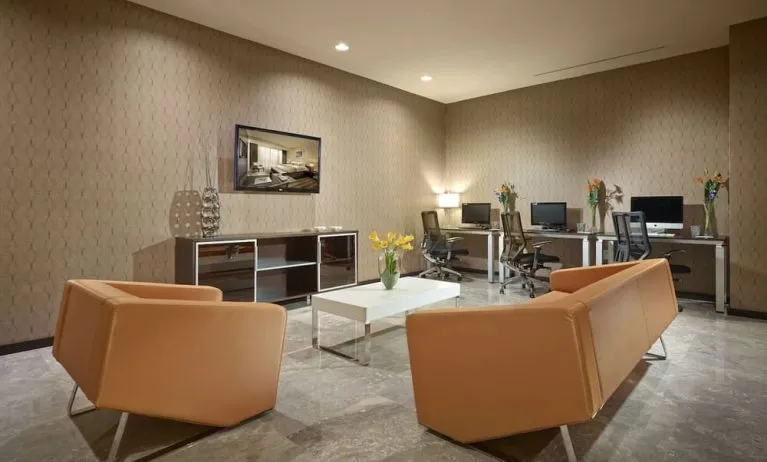 Business center with computers,ergonomic chairs and lounge area at EB Hotel Miami.