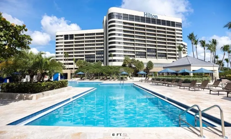 Outdoor pool with lounge seating at Hilton Miami Airport Blue Lagoon.