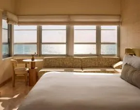 Day use room with king bed, large windows, lounge area and private bathroom at Shelborne South Beach.