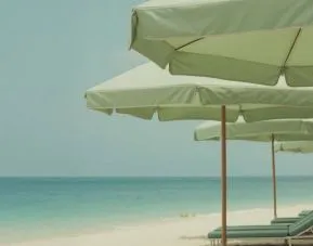 Private beach access with lounge seating and umbrellas at Shelborne South Beach.