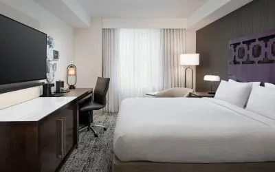 Delux king room with TV, work desk, and natural light at Courtyard San Diego Downtown.