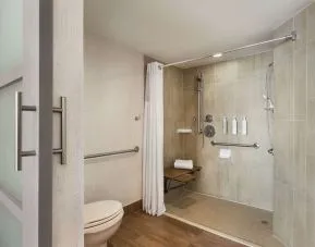 Private guest bathroom with shower and free toiletries at Embassy Suites By Hilton Miami - International Airport.
