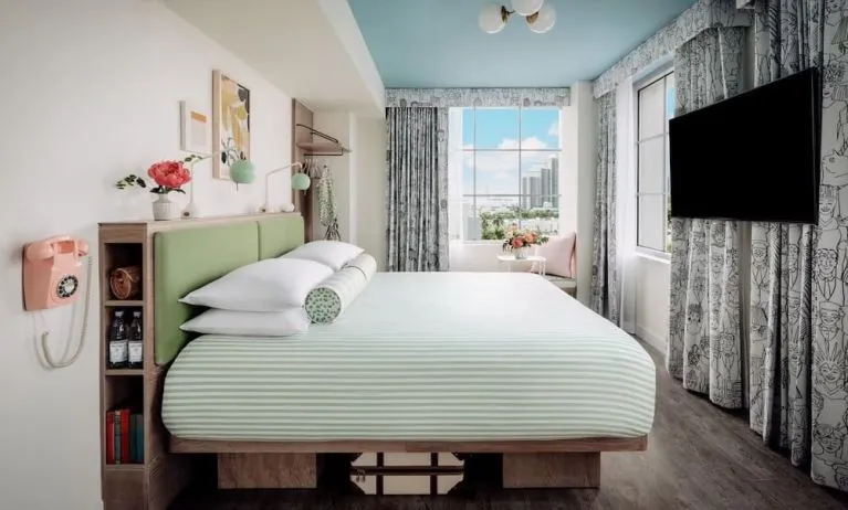Day use room with king bed, TV screen, large windows and private bathroom at The Goodtime Hotel.