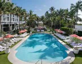 Beautiful outdoor pool with lounge chairs at Cadillac Hotel & Beach Club, Autograph Collection.