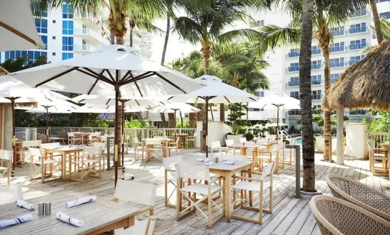 Outdoor lounge and dining area with comfortable seating at Cadillac Hotel & Beach Club, Autograph Collection.