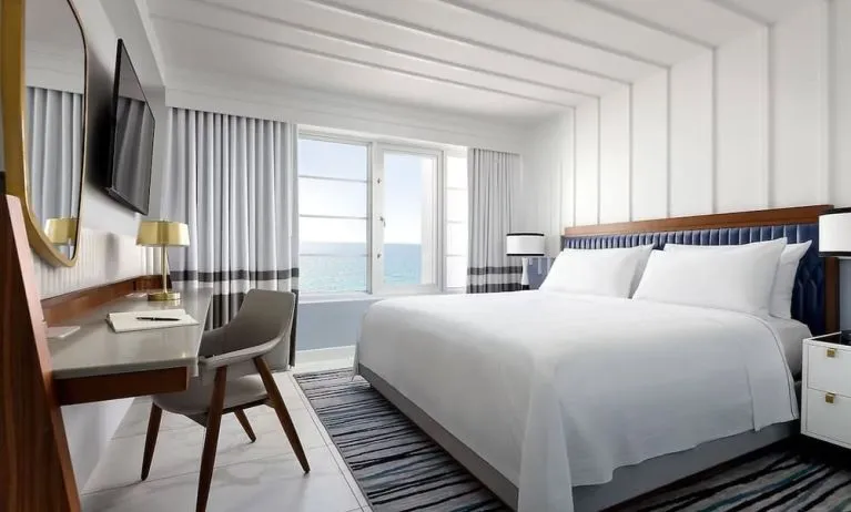 Day use room with king bed, large windows, work desk and private bathroom at Cadillac Hotel & Beach Club, Autograph Collection.