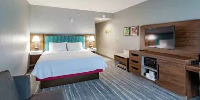 Comfortable king bed in a hotel room at the Hampton Inn Madison, OH.