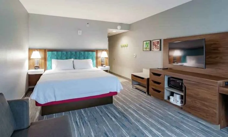 Comfortable king bed in a hotel room at the Hampton Inn Madison, OH.