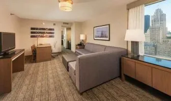 Spacious living room with working station in a king suite at the Embassy Suites by Hilton Chicago Magnificent Mile.