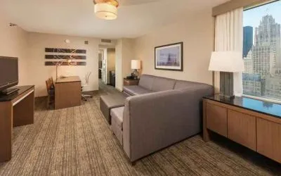 Spacious living room with working station in a king suite at the Embassy Suites by Hilton Chicago Magnificent Mile.