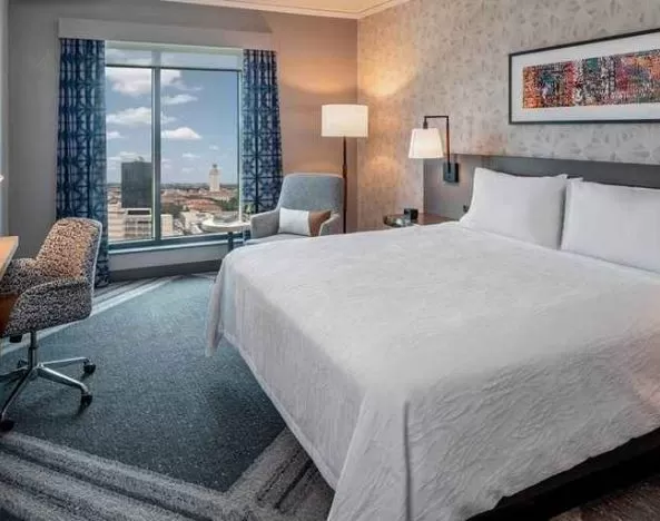 Comfortable king bedroom with city views and natural light at Hilton Garden Inn Austin University.