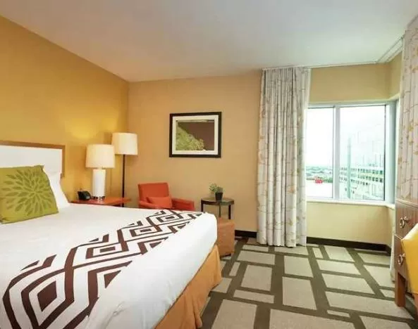 Luxurious king suite with TV, work area, and lounge at Embassy Suites by Hilton Houston Downtown.