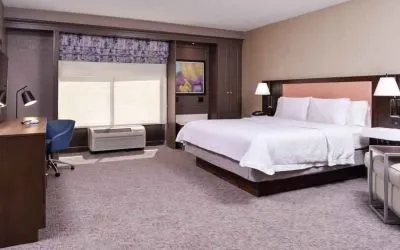 Spacious and bright king guestroom with window and desk at the Hampton Inn Albuquerque, University-Midtown (UNM).