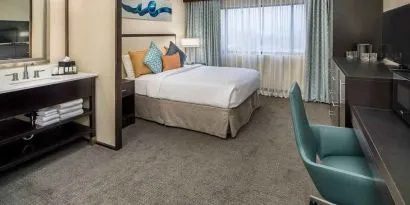 Spacious king room with work desk ideal for working remotely at Embassy Suites by Hilton Seattle Tacoma International Airport.