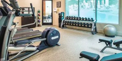 Fully equipped fitness center with treadmills and weights at at Embassy Suites by Hilton Seattle Tacoma International Airport.
