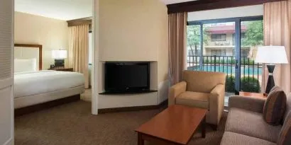 Hotel suite with king size bed, sofa and pool view at the DoubleTree Suites by Hilton Cincinnati-Blue Ash.