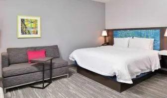King bedroom with sofa at the Hampton Inn & Suites St. Paul Oakdale/Woodbury by Hilton.