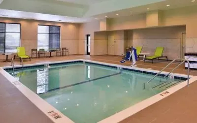 Indoor pool area with lounges and chairs at the Hampton Inn & Suites St. Paul Oakdale/Woodbury by Hilton.