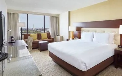 Bright king bedroom with sofa, window and desk at the DoubleTree by Hilton Washington DC - Crystal City.
