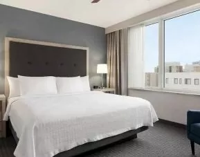 Comfortable king bed with lots of natural light at Homewood Suites by Hilton University City Philadelphia, PA.