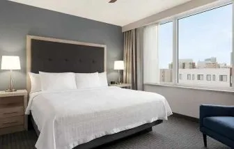 Comfortable king bed with lots of natural light at Homewood Suites by Hilton University City Philadelphia, PA.