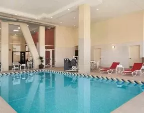 Lovely indoor pool with surrounding seating area and sun beds at Homewood Suites by Hilton University City Philadelphia, PA.