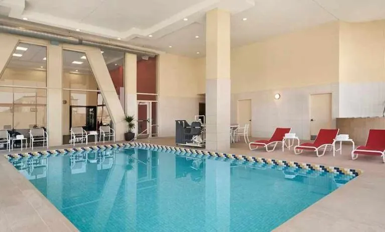 Lovely indoor pool with surrounding seating area and sun beds at Homewood Suites by Hilton University City Philadelphia, PA.