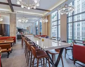 comfortable restaurant and coworking space with lots of natural light at Canopy by Hilton Jersey City Arts District.