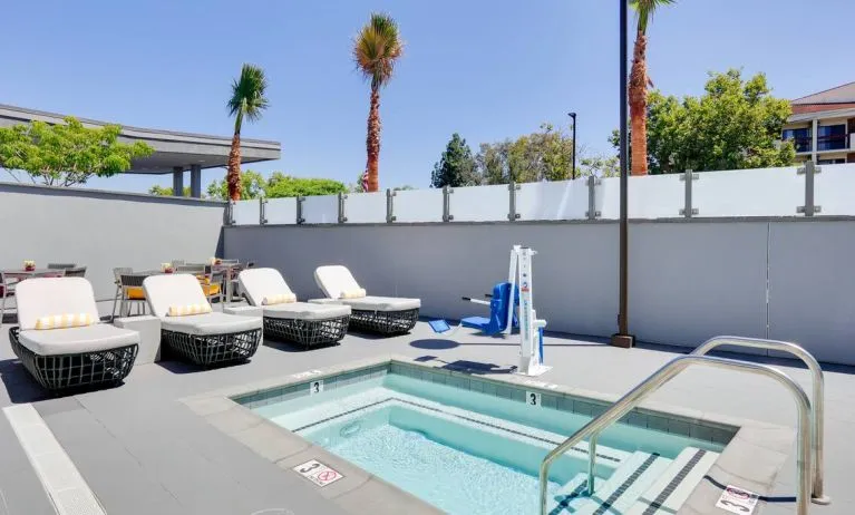small outdoor dipping pool in beautiful surroundings with sun beds at Hampton Inn Irvine Spectrum Lake Forest.