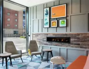 Lobby workspace by the fireplace at the Hampton by Hilton Belfast City Centre.