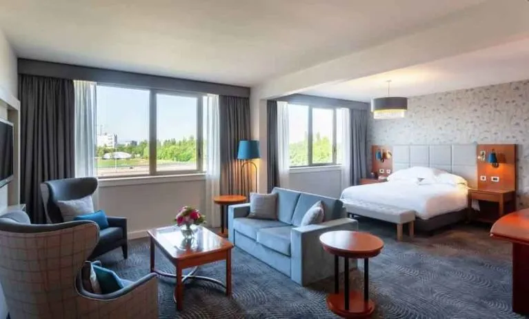 Spacious king suite with living room and working station at the Hilton Strasbourg.