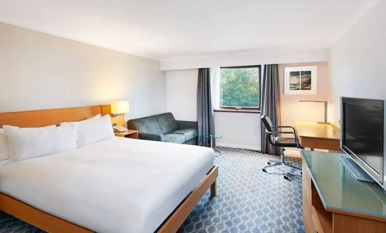 Spacious king room with TV, comfortable work desk and natural light at Hilton London Watford.