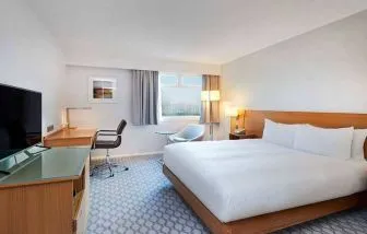 Comfortable king room with TV and work desk at Hilton London Watford.